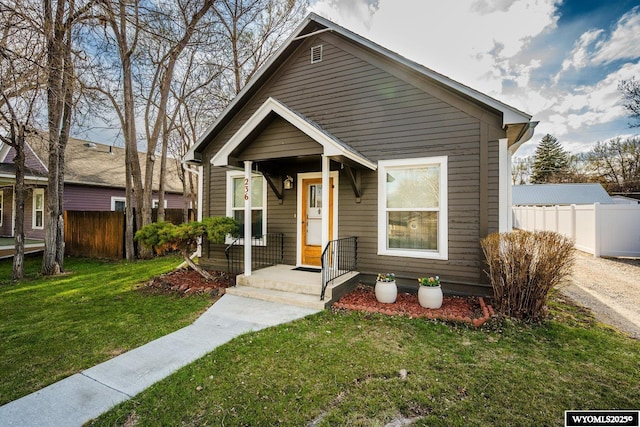 bungalow-style house featuring a front lawn and fence