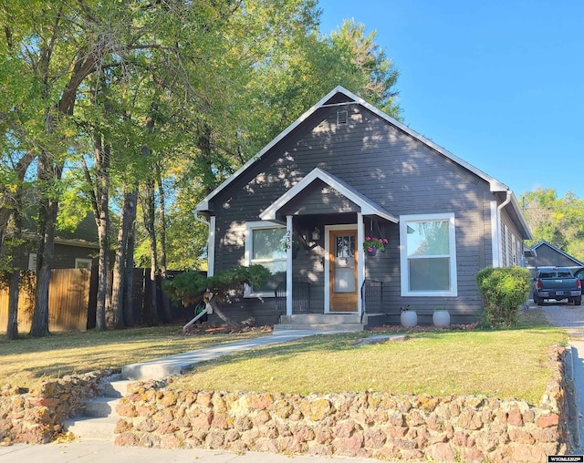 bungalow with fence and a front yard