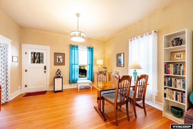 dining area with light wood finished floors and baseboards