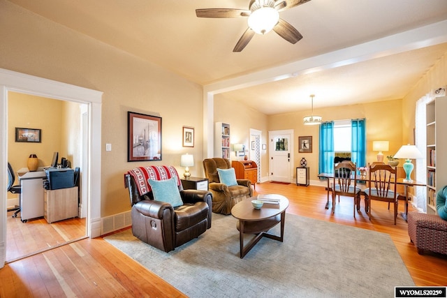 living area with light wood-style flooring, baseboards, and ceiling fan