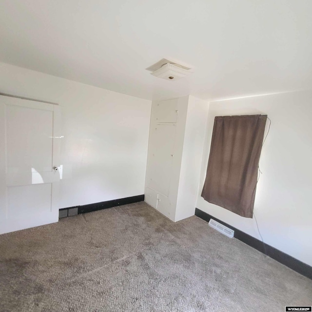carpeted spare room featuring visible vents