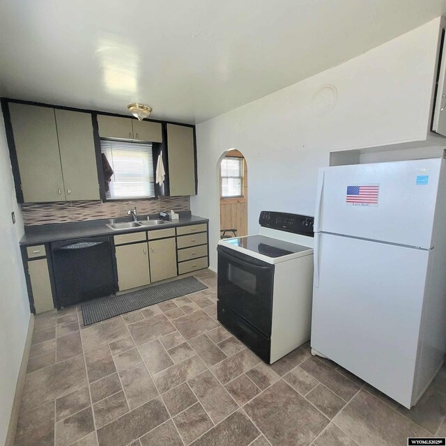 kitchen featuring a sink, decorative backsplash, dishwasher, freestanding refrigerator, and electric range
