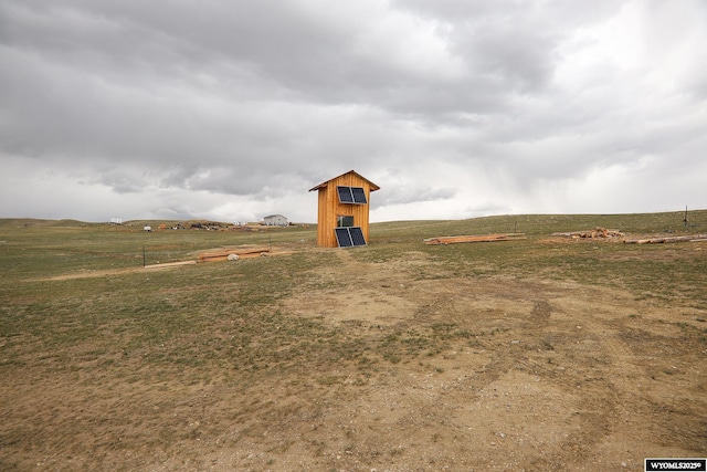 view of yard with a rural view and an outdoor structure