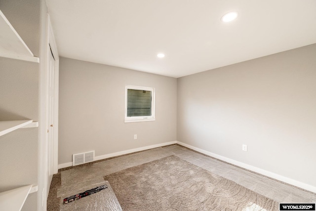 carpeted empty room featuring baseboards, visible vents, and recessed lighting