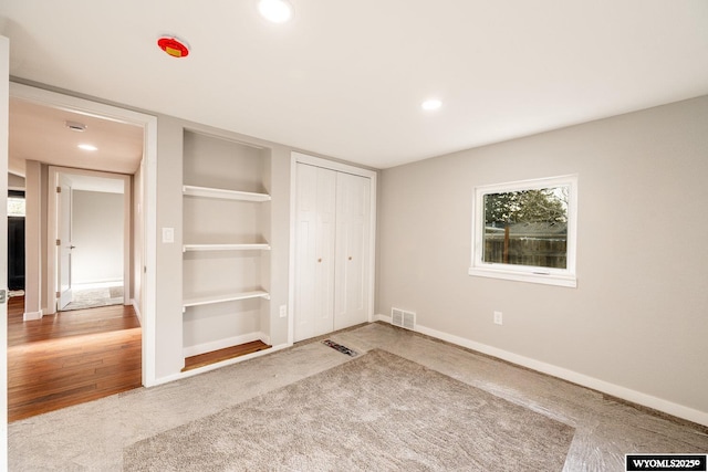 unfurnished bedroom with visible vents, a closet, recessed lighting, and baseboards