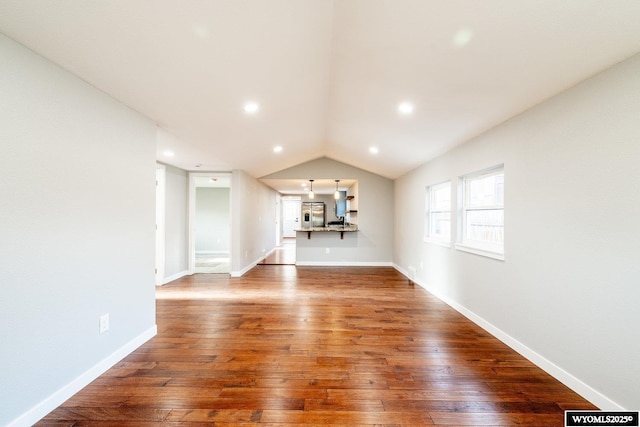 unfurnished living room with wood-type flooring, recessed lighting, lofted ceiling, and baseboards