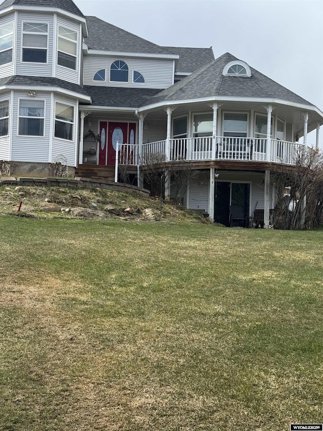 view of front of home with a front yard and roof with shingles