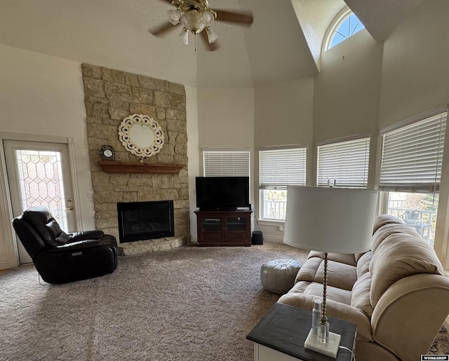 living room with a high ceiling, ceiling fan, carpet floors, and a fireplace