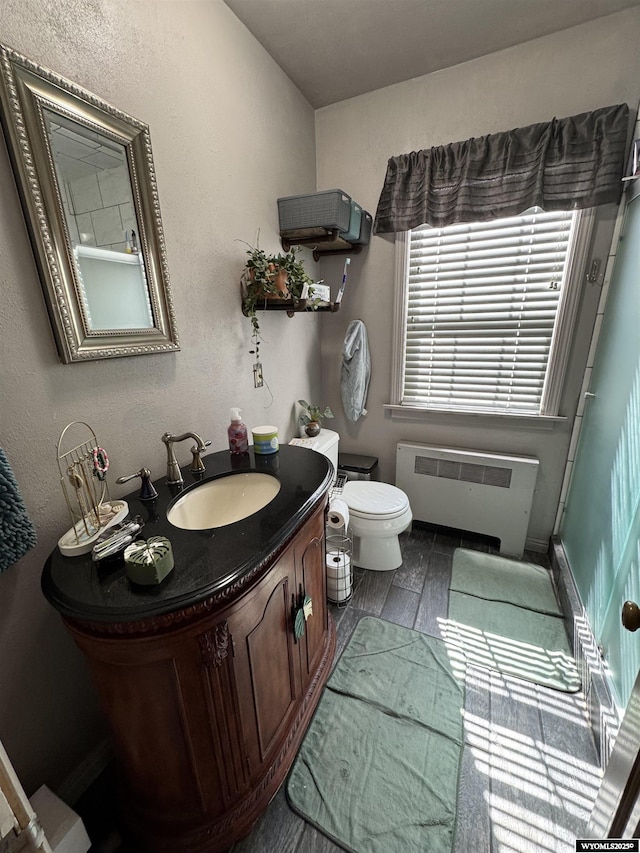 716 B St, Rock Springs, WY 82901 - bathroom with toilet, radiator heating unit, vanity, and baseboards