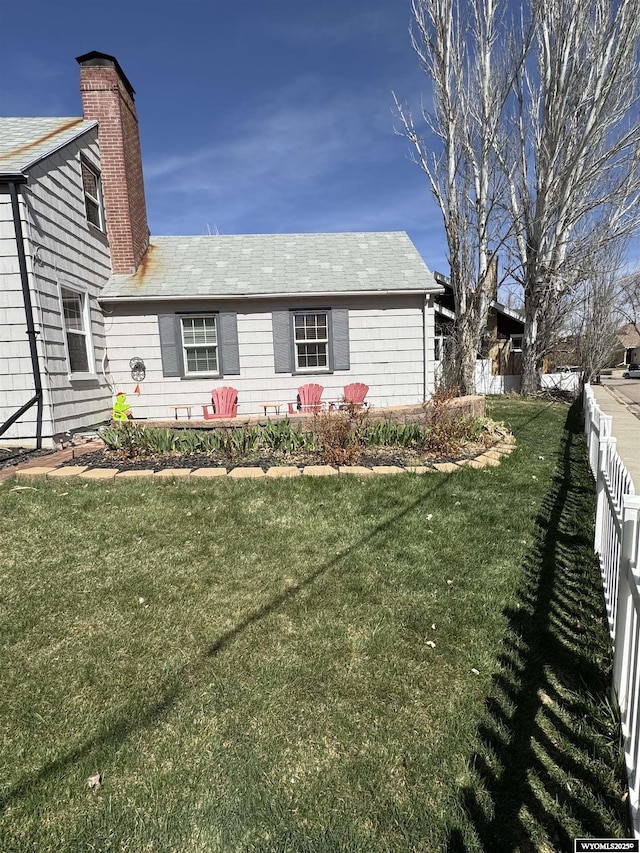 716 B St, Rock Springs, WY 82901 - view of front of home with a front lawn, fence, and a chimney