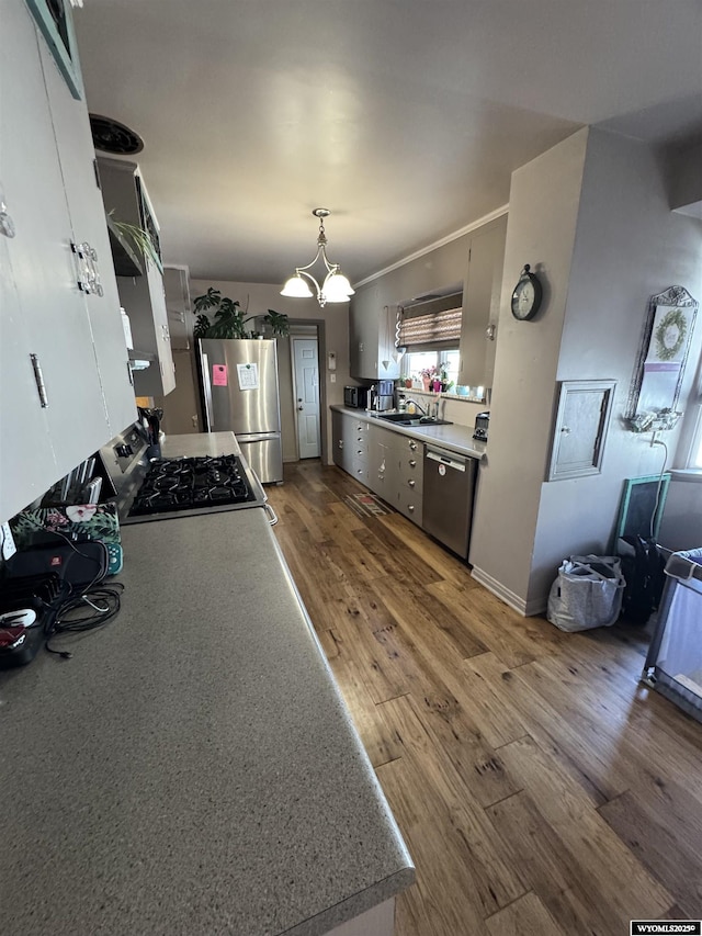 716 B St, Rock Springs, WY 82901 - kitchen featuring a sink, appliances with stainless steel finishes, wood finished floors, and light countertops