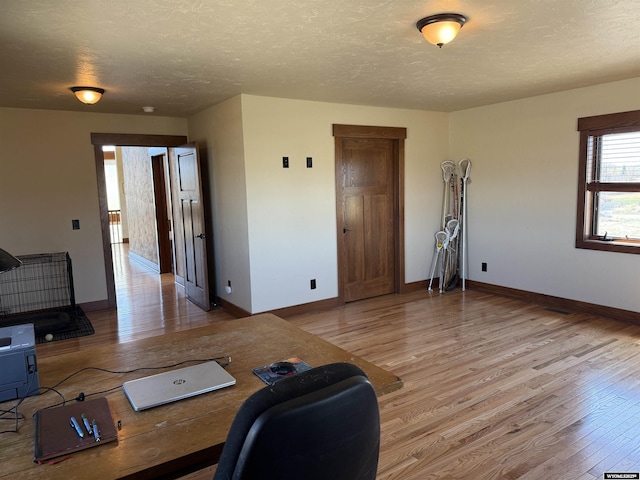 office space featuring a textured ceiling, wood finished floors, and baseboards