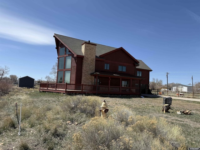 exterior space featuring a chimney, fence, and a wooden deck