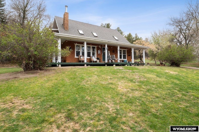 rear view of house with a chimney, a porch, roof with shingles, and a lawn