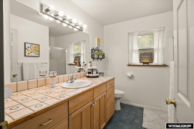 full bathroom with a shower stall, vanity, tile patterned floors, toilet, and baseboards