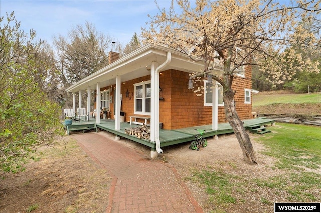 view of home's exterior featuring a chimney and a porch