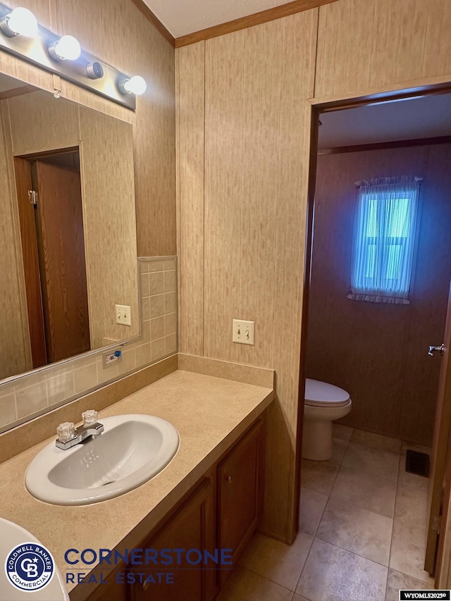 bathroom with ornamental molding, toilet, tile patterned flooring, and vanity