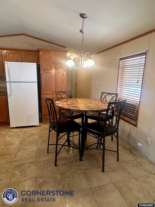 dining room featuring light tile patterned floors, crown molding, and vaulted ceiling