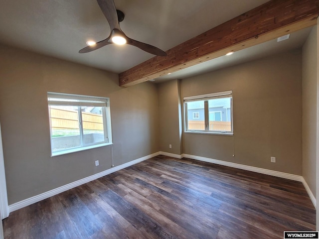 spare room with beam ceiling, a ceiling fan, dark wood-style floors, and baseboards