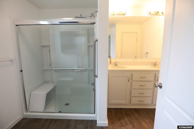 full bathroom featuring vanity, wood finished floors, and a stall shower