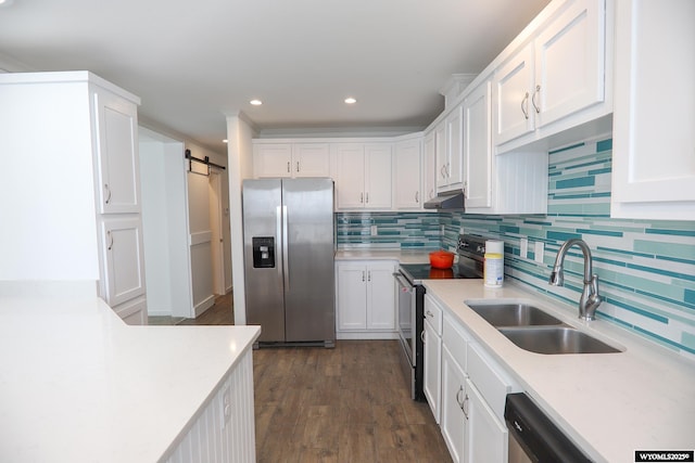 kitchen featuring a sink, light countertops, white cabinets, under cabinet range hood, and stainless steel appliances