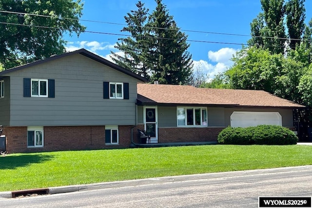 tri-level home featuring a front lawn and brick siding