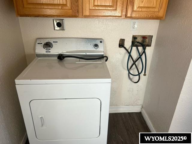 laundry room with baseboards, dark wood finished floors, washer / clothes dryer, and cabinet space