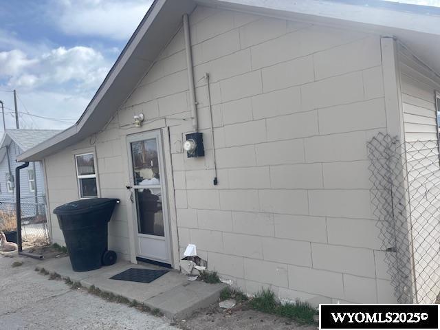view of side of property with fence and concrete block siding