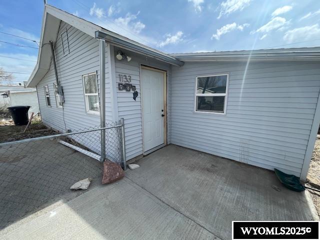 property entrance with fence and a patio area