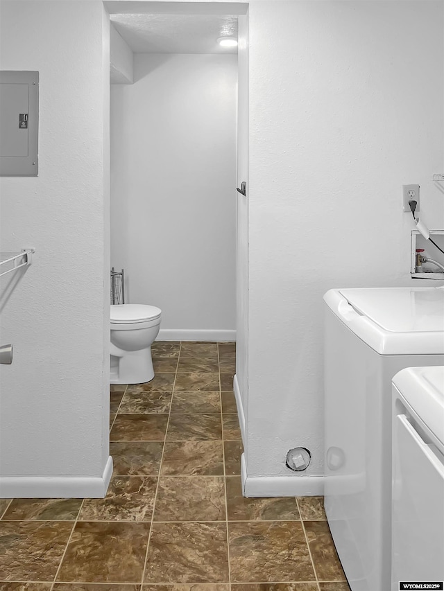 336 Emerson Ave, Evanston, WY 82930 - bathroom with baseboards, washing machine and dryer, electric panel, and toilet