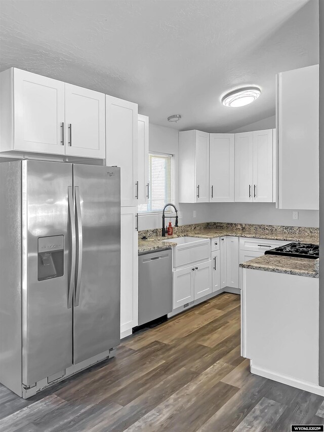 336 Emerson Ave, Evanston, WY 82930 - kitchen featuring light stone counters, white cabinetry, dark wood-type flooring, and stainless steel appliances