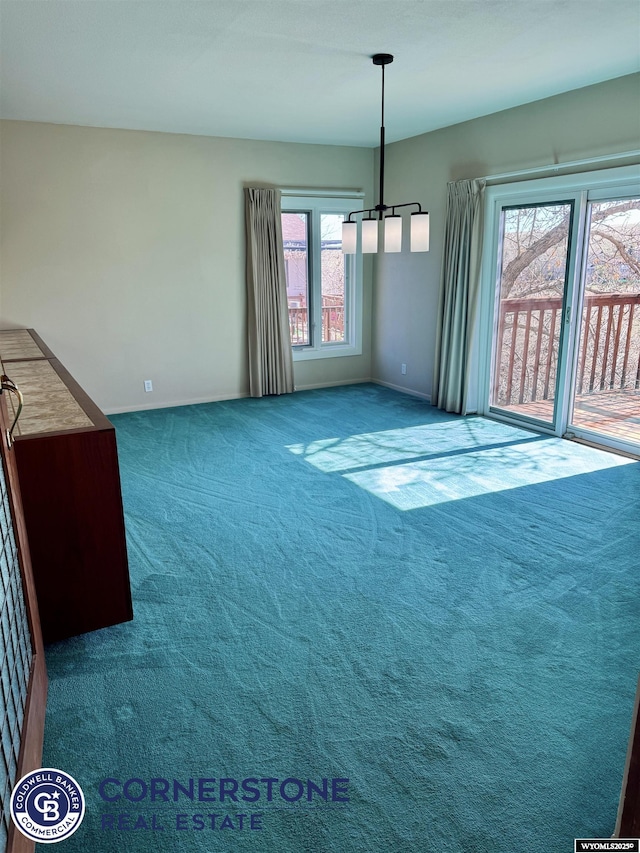 unfurnished dining area featuring baseboards and carpet