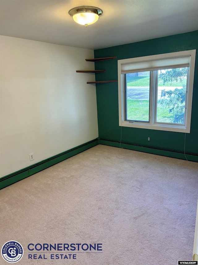 empty room featuring carpet floors and baseboard heating