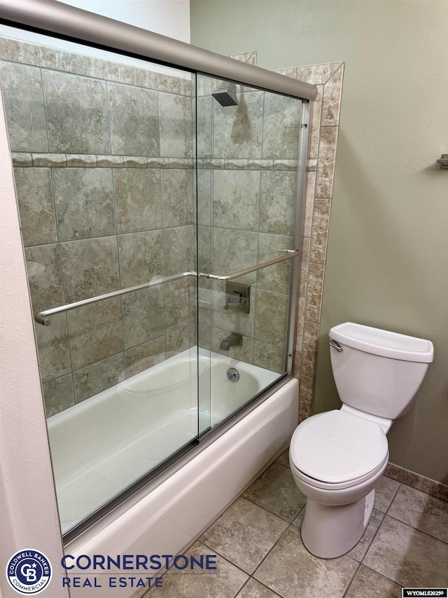 full bathroom with tile patterned flooring, combined bath / shower with glass door, and toilet