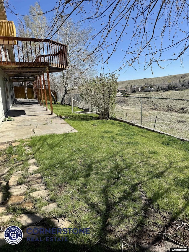 view of yard with a patio area, fence, and a deck