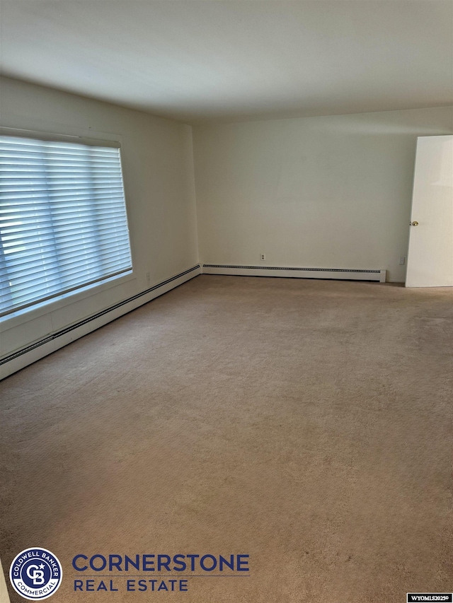 unfurnished room with carpet and a baseboard heating unit
