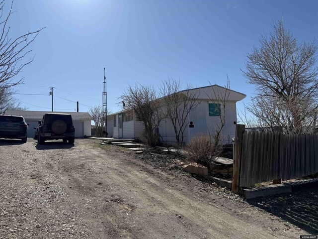 view of property exterior featuring fence and dirt driveway