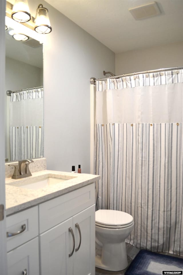 full bath featuring toilet, visible vents, curtained shower, and vanity