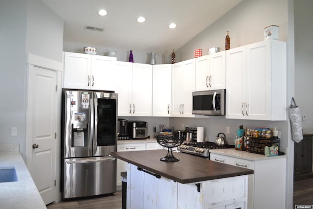 kitchen featuring appliances with stainless steel finishes, dark wood finished floors, white cabinetry, visible vents, and butcher block counters