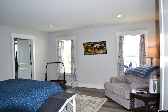 bedroom featuring baseboards, dark wood finished floors, multiple windows, and visible vents