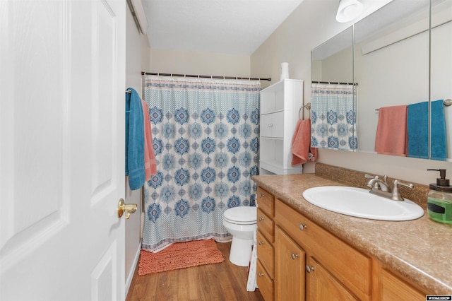 full bathroom featuring vanity, a shower with curtain, toilet, and wood finished floors