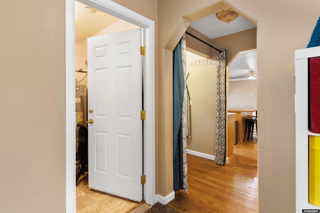 hallway featuring baseboards and wood finished floors