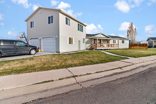 traditional home with fence, a front lawn, a garage, a porch, and concrete driveway