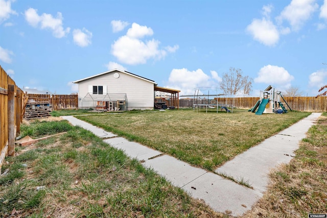 view of yard featuring a playground, a fenced backyard, and a trampoline