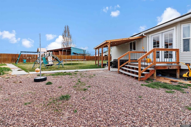 view of yard featuring a fenced backyard, a trampoline, and a playground