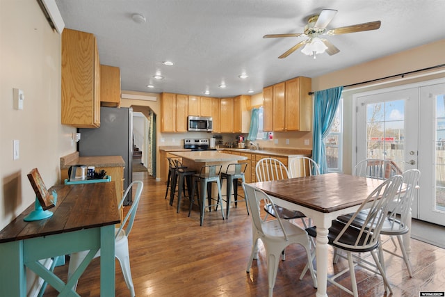 dining room with a ceiling fan, a healthy amount of sunlight, and light wood-style flooring