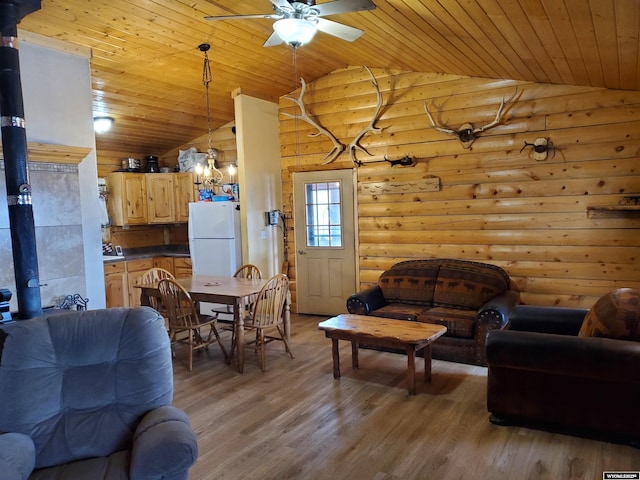 living area with vaulted ceiling, wood ceiling, and a wood stove