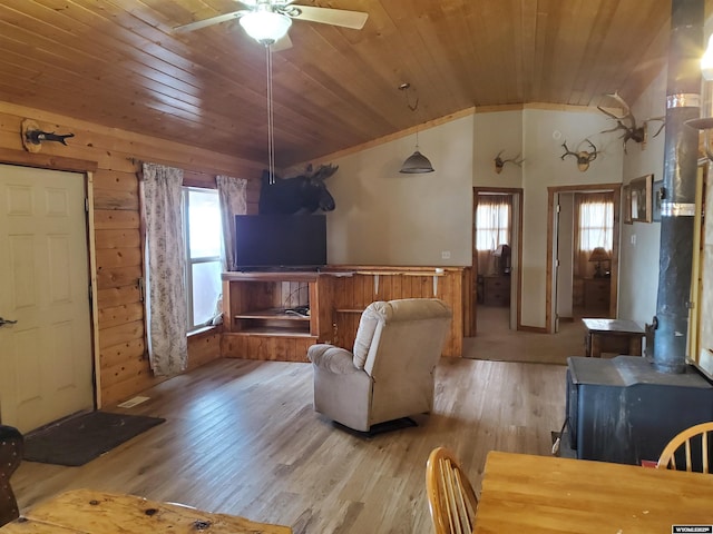 living room with wooden walls, light wood finished floors, a ceiling fan, wooden ceiling, and lofted ceiling