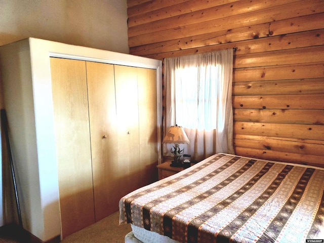 bedroom featuring log walls, carpet, and a closet