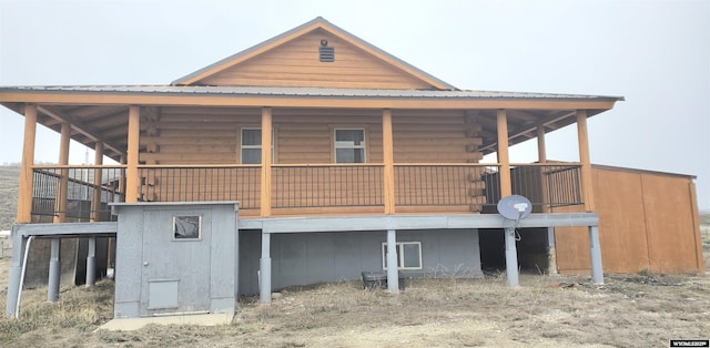 back of property featuring log siding and metal roof